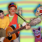 Stewzo the clown with a guitar and puppets