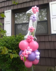 Birthday balloon delivery - foil balloon with a large silver number one balloon foil on top of round pink and purple balloons decorated with balloon flowers
