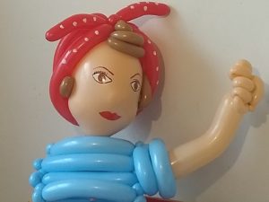 Rosie the Riveter balloon wearing a red bandanna balloon over her brown hair and a twisted balloon blue shirt