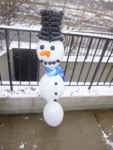 Tall snowman balloon with a twisted top hat.  