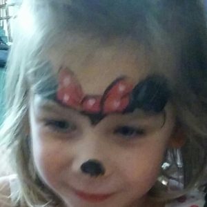 Girl face painted as Minnie Mouse for a party