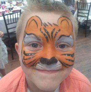 Boy face painted as a tiger for a communion