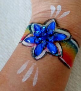 Colorful star bracelet with gems painted on a hand for an event