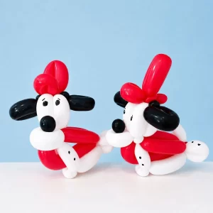 Two red, white and black balloon dogs created by a Long Island balloon twister.