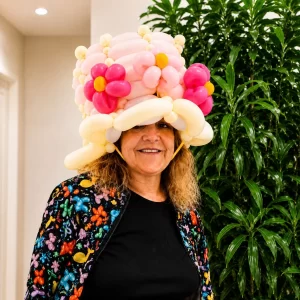 Long Island balloon twister from Daisy’s Art and Magic wearing an elaborate pink flower balloon hat.
